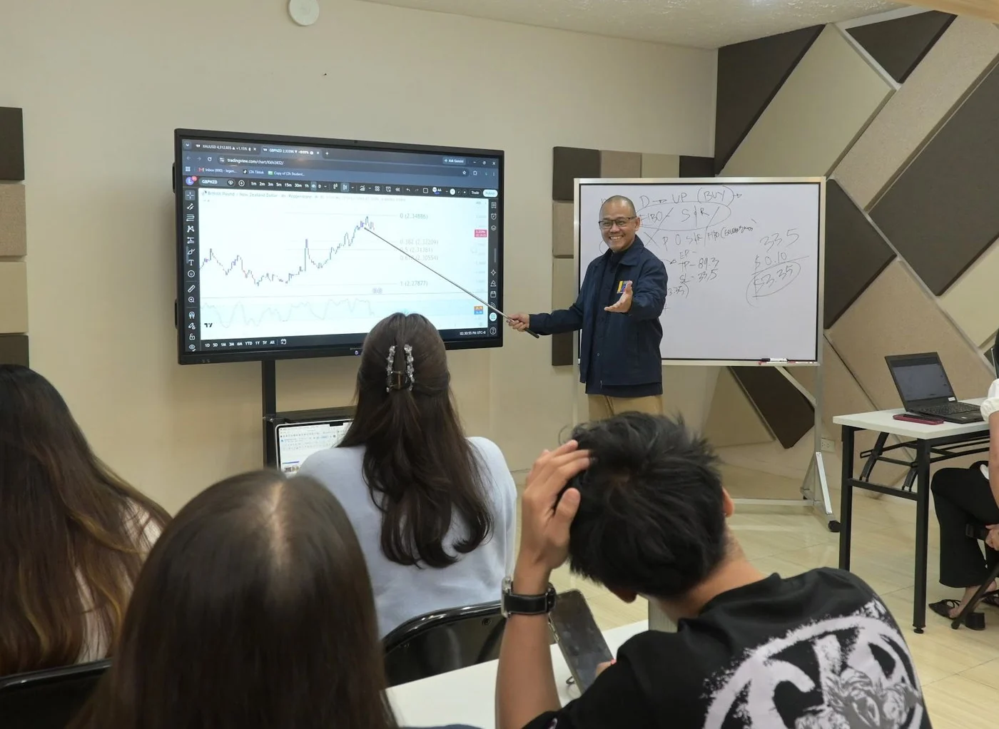 An LTA coach teaching students during a classroom trading lesson
