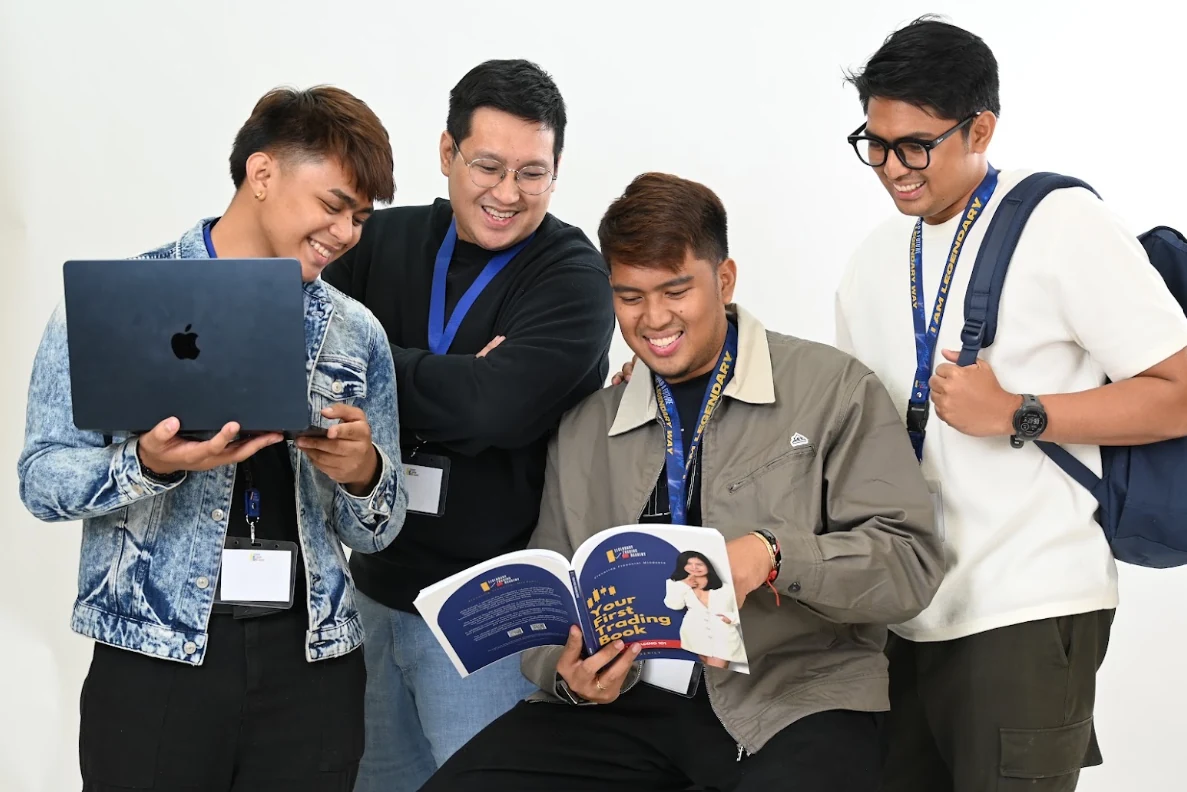 LTA learners sharing academy books and a laptop